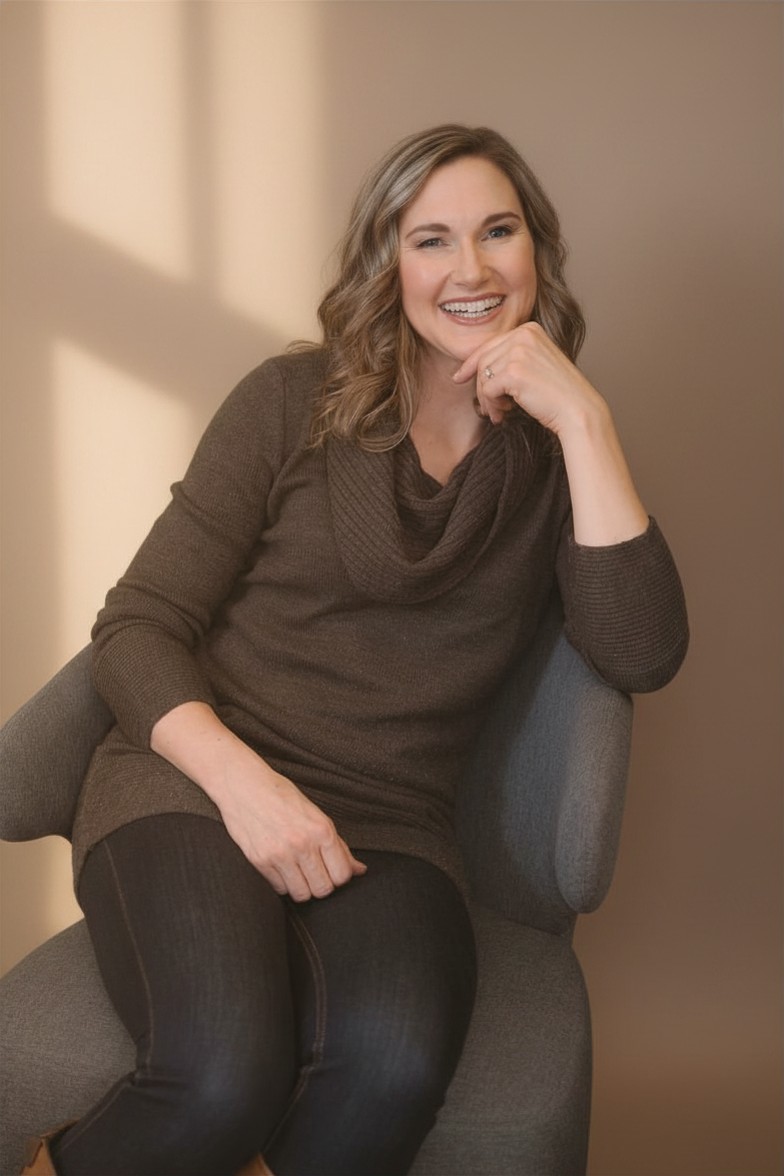 Burnout and resilience coach Linda Bartholme smiling in a chair, offering midlife career and leadership coaching.