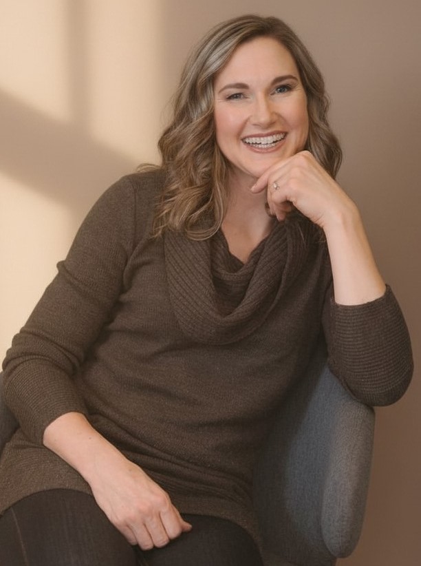 Burnout and resilience coach Linda Bartholme smiling in a chair, offering midlife career and leadership coaching.