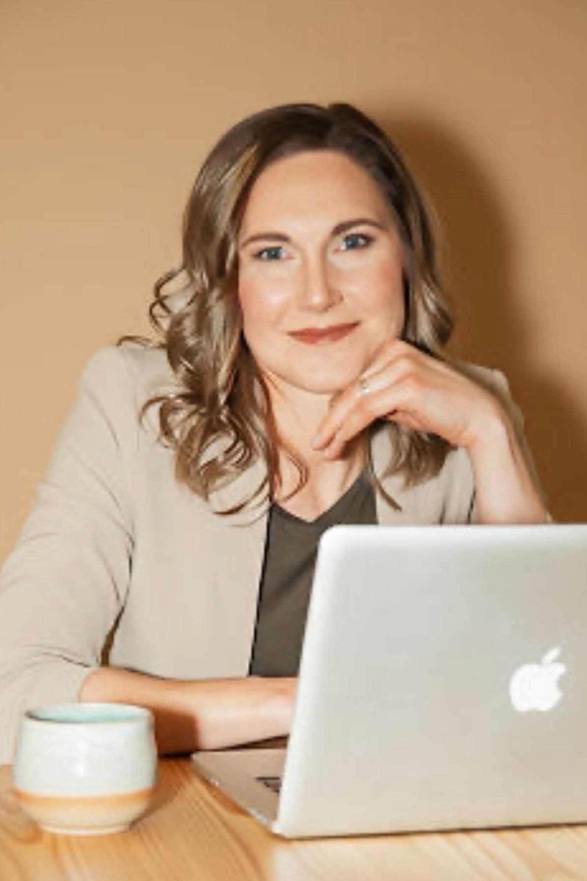 Linda Bartholme at her desk with a laptop, designing customized workplace wellness programs for corporate clients.