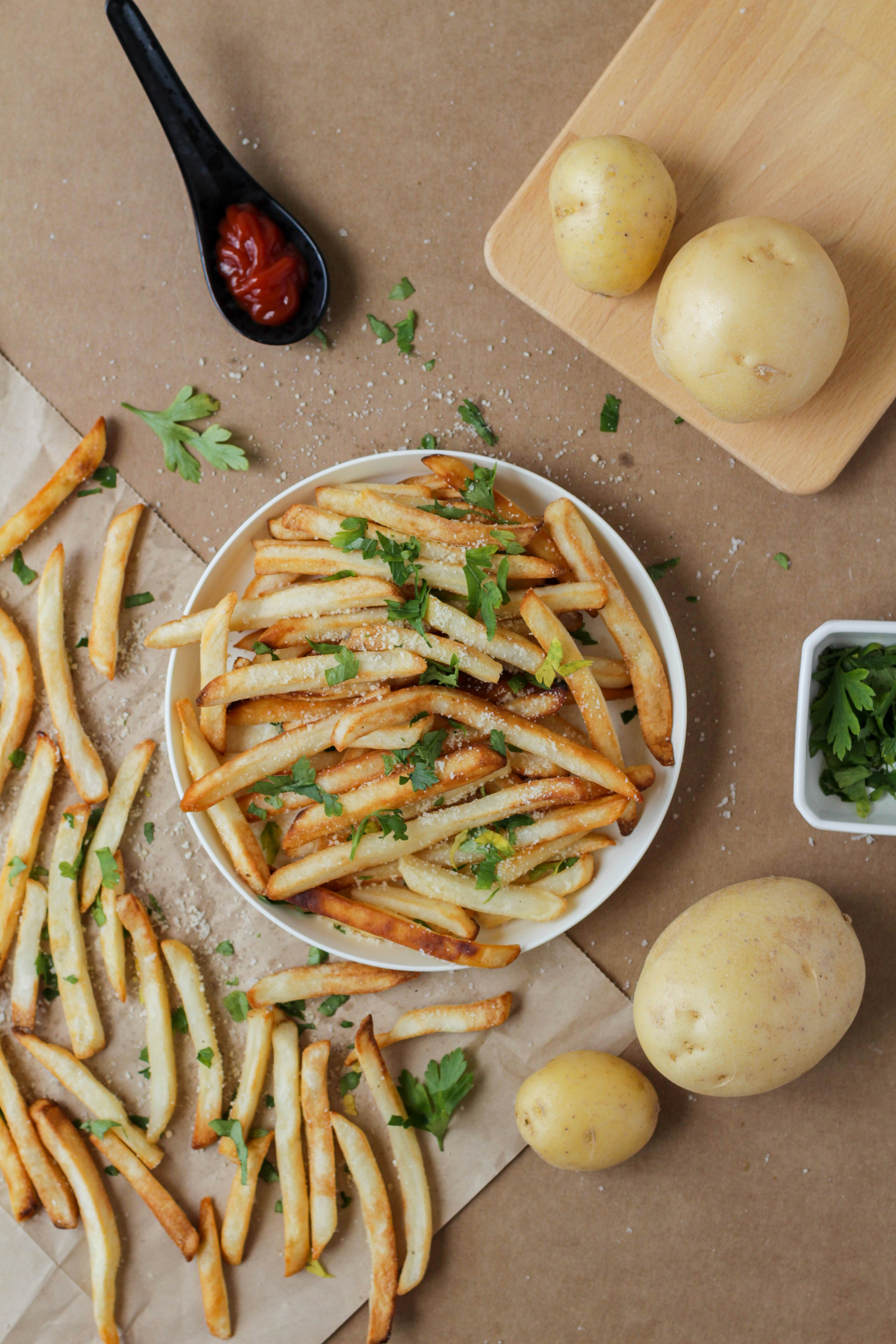 Air fryer on a kitchen counter beside fresh ingredients