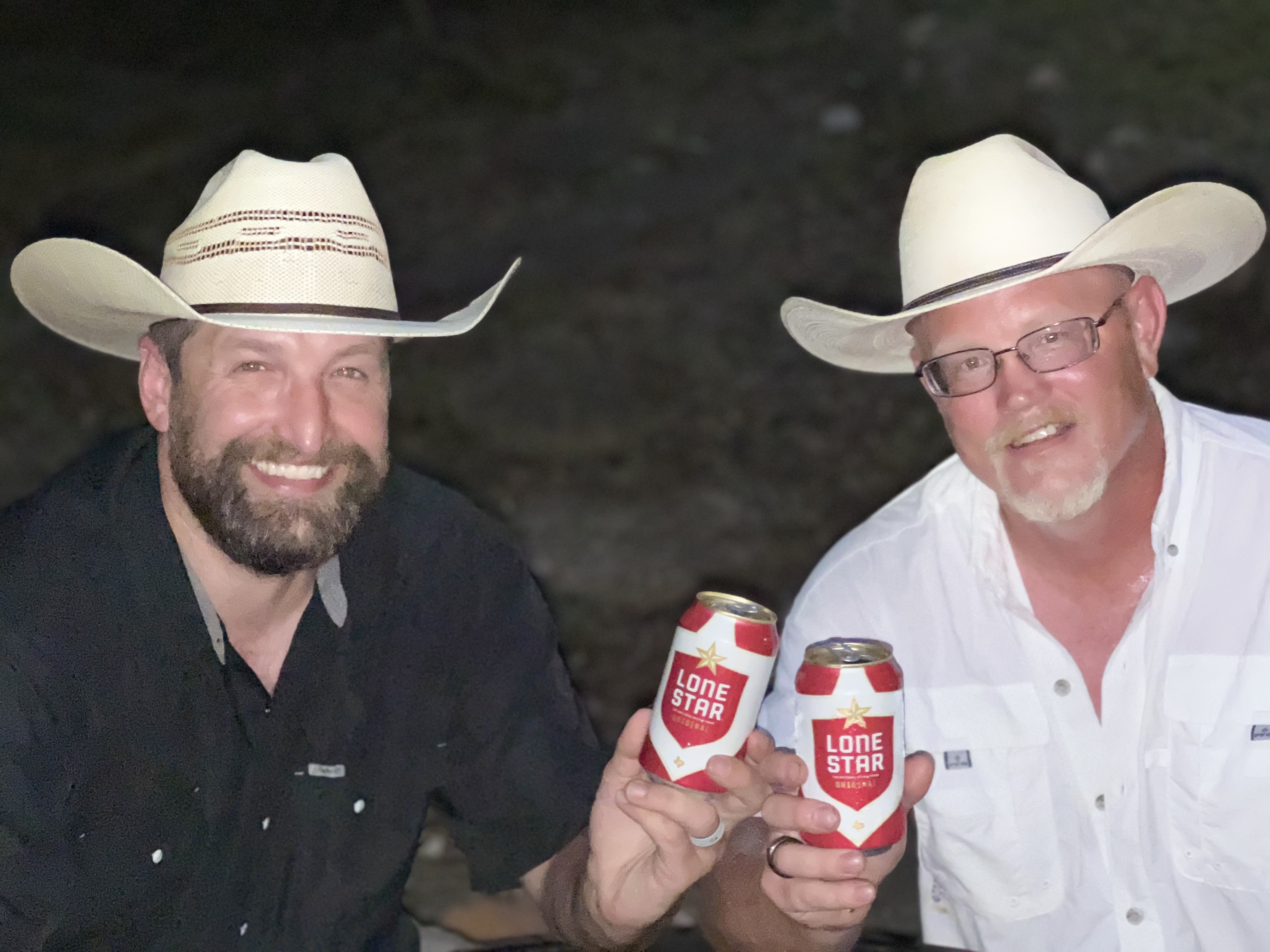 Friends with beers, one wearing a hat