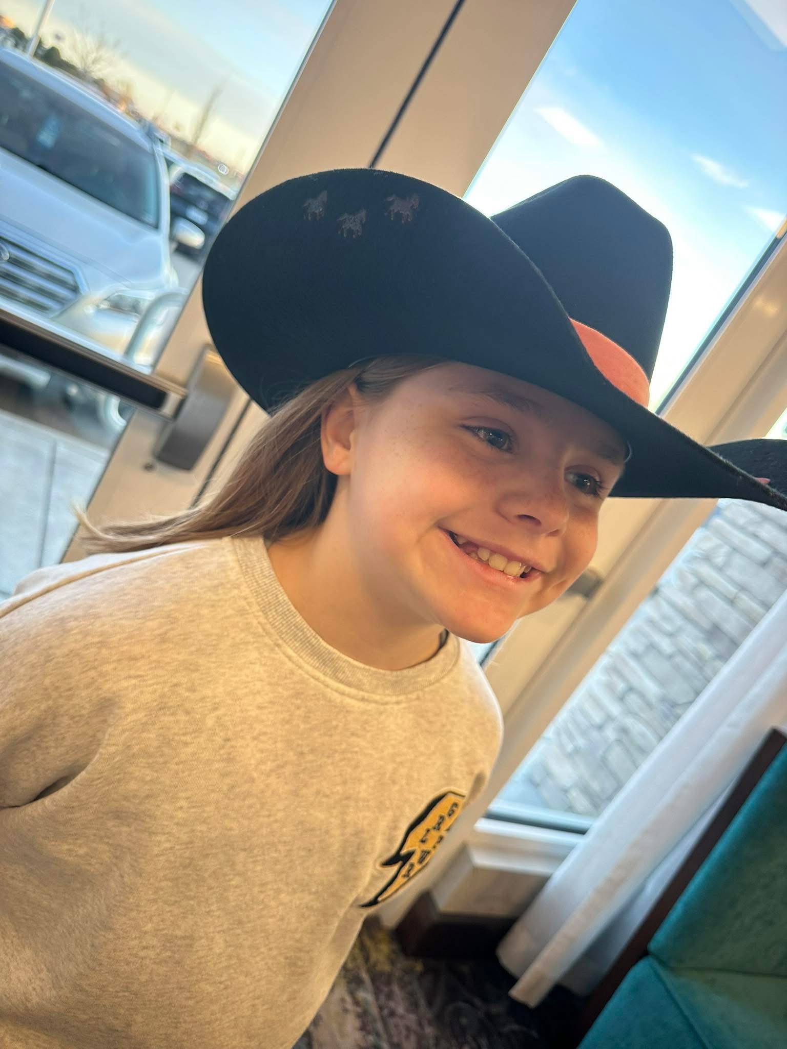 Young guest smiling in her new hat