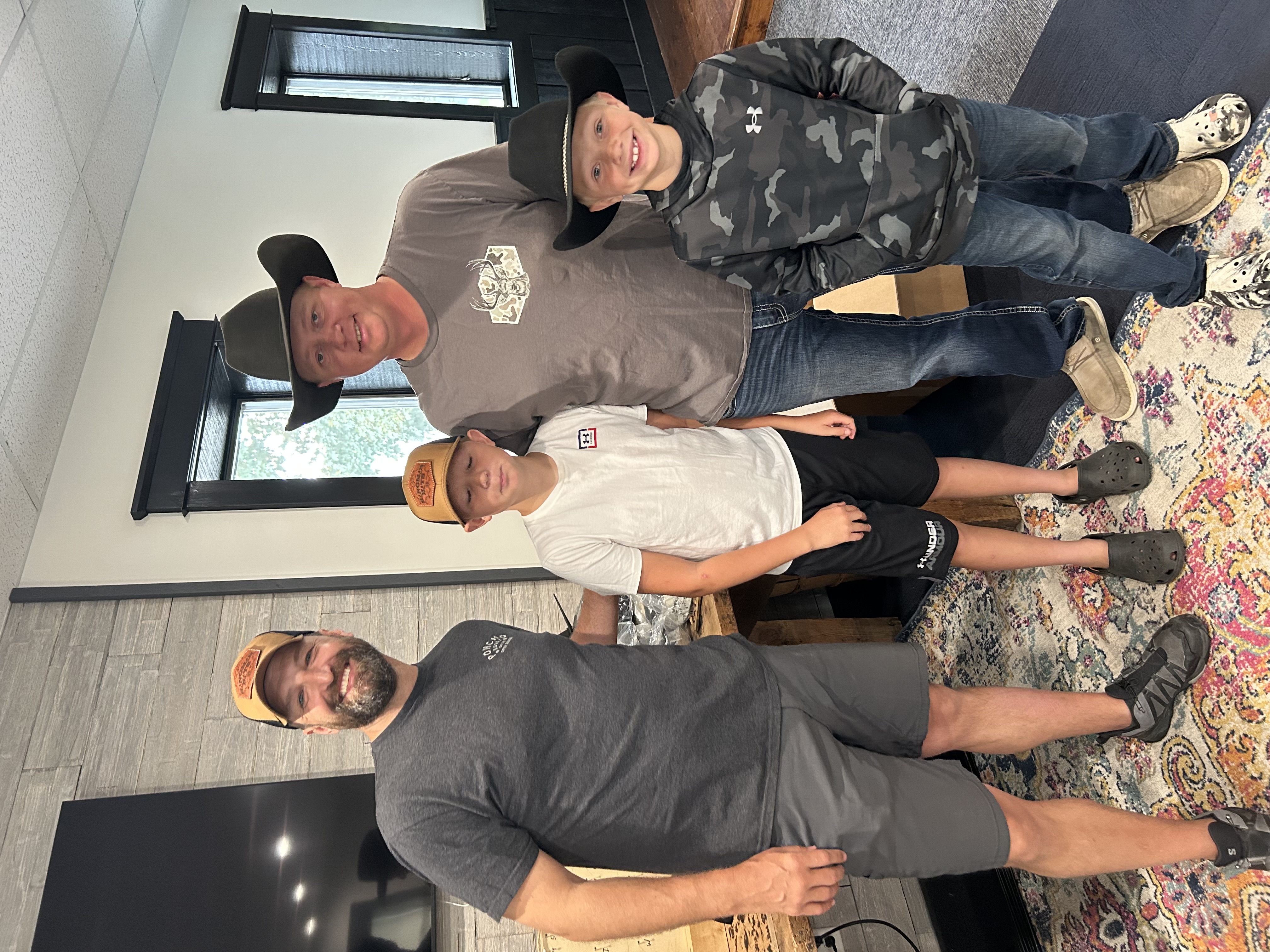Justin with a father and his sons after fitting their hats