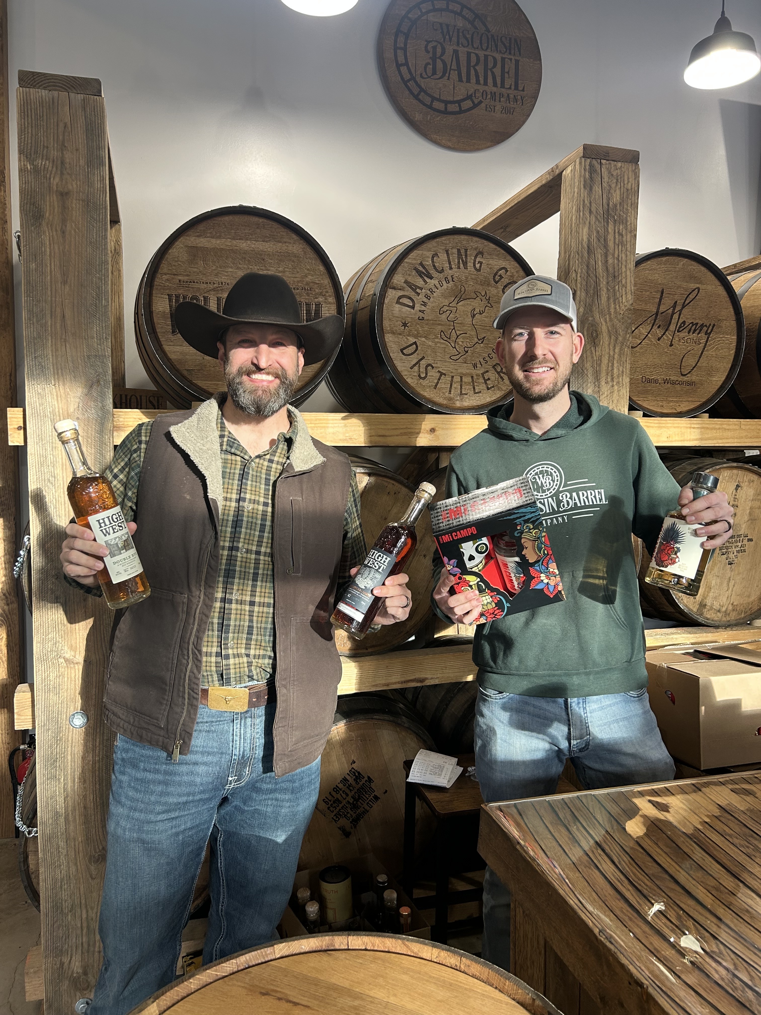 Two guys in hats holding whisky bottles