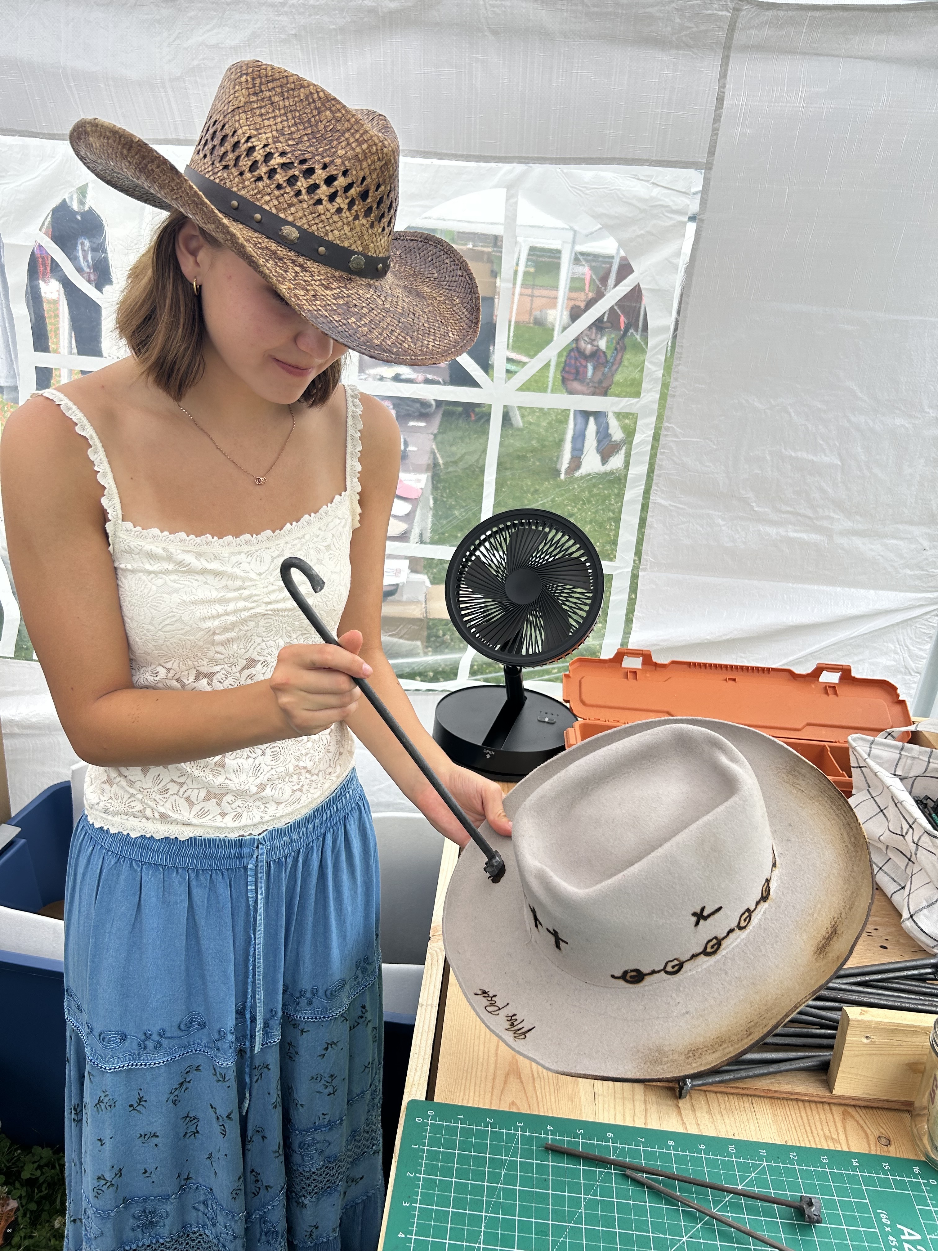 The founders' youngest daughter with a straw hat and shaping tools at home