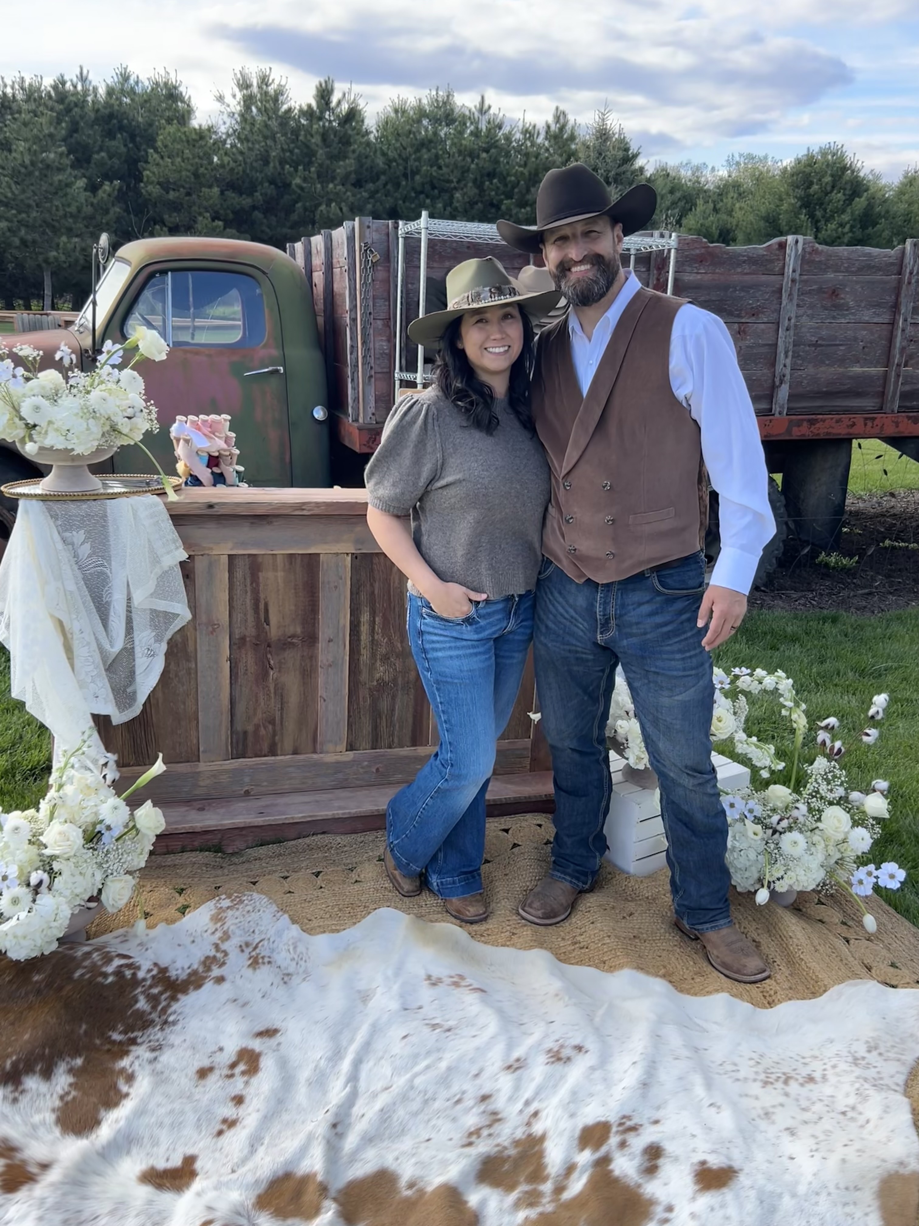 Justin and Jen standing in front of the Hangman Hats bar setup