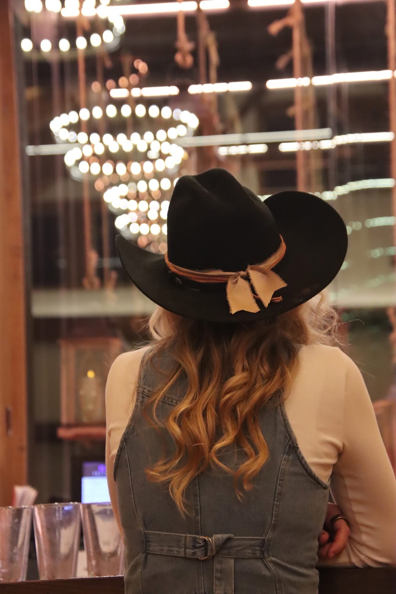Guest wearing a hat with string lights in the background