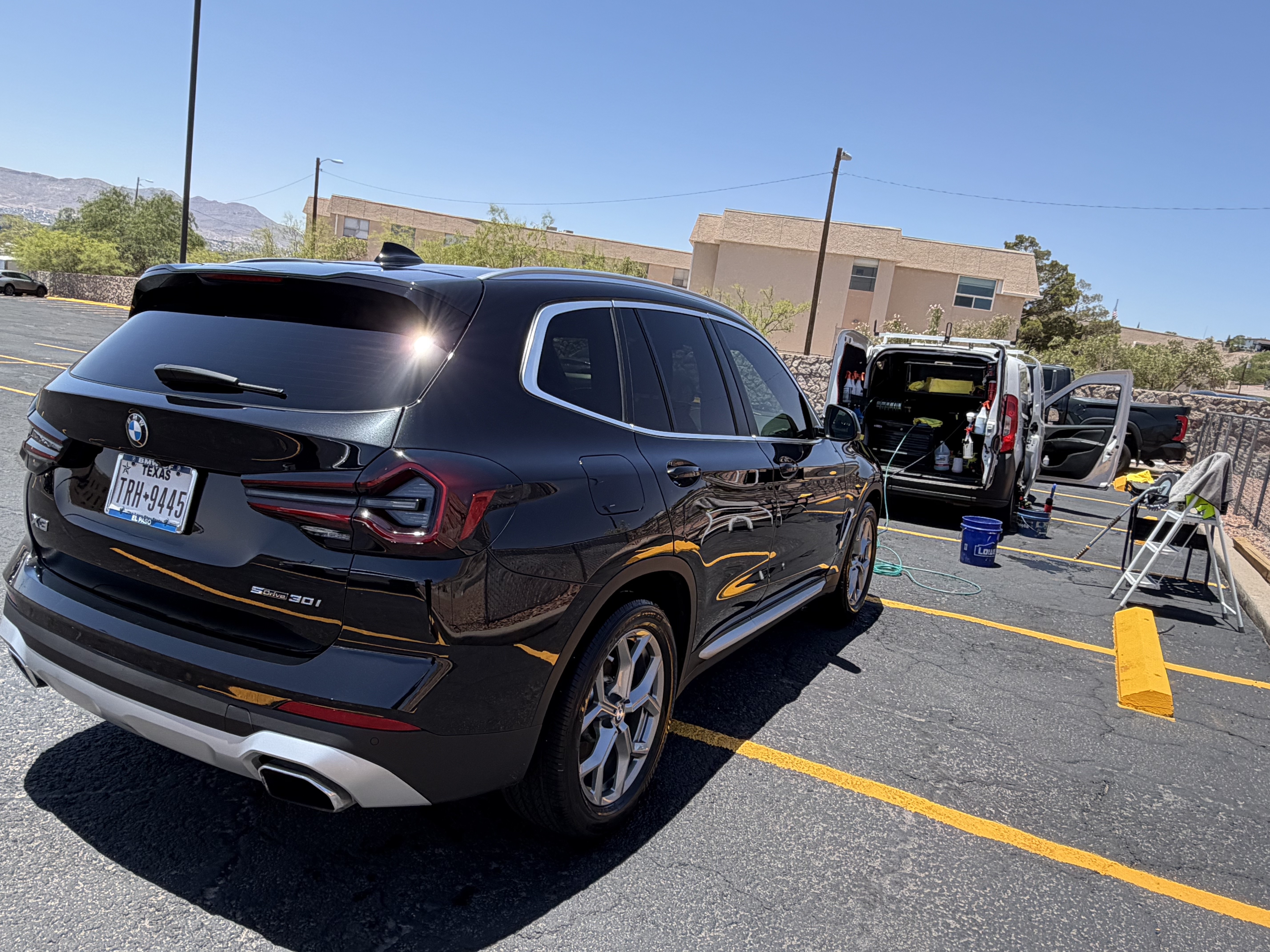 Mobile detailing setup beside a finished BMW X3