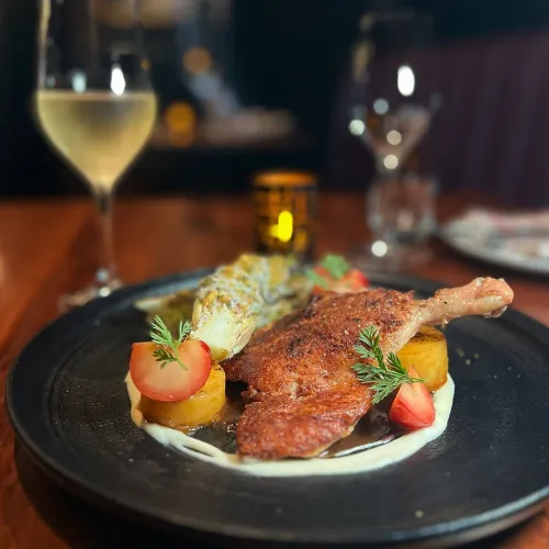 Plated Dish with a Glass of Wine at Et Voilà French Bistro