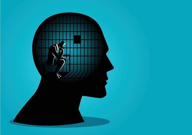 Silhouette of person's head containing imprisoned figure in jail cell, representing internal psychological prison, trauma bonding, narcissistic abuse effects, and mental imprisonment from manipulation