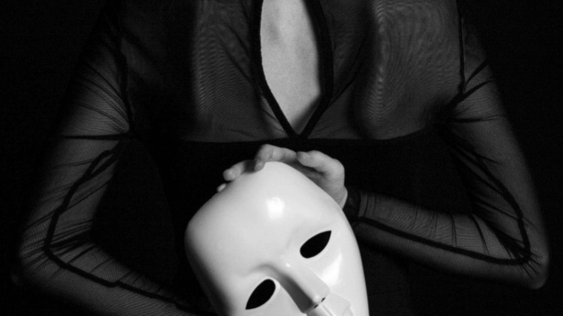 Person holding white mask revealing false persona, representing narcissistic mask, false self projection, hidden identity, and the deceptive facade narcissists use to manipulate others