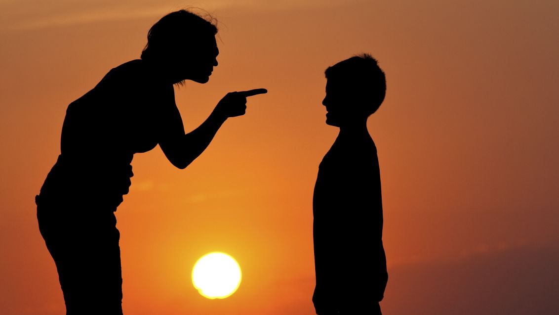Silhouette of adult pointing accusingly at child against sunset, representing verbal abuse, narcissistic parenting, emotional abuse of children, blame patterns, and toxic family dynamics