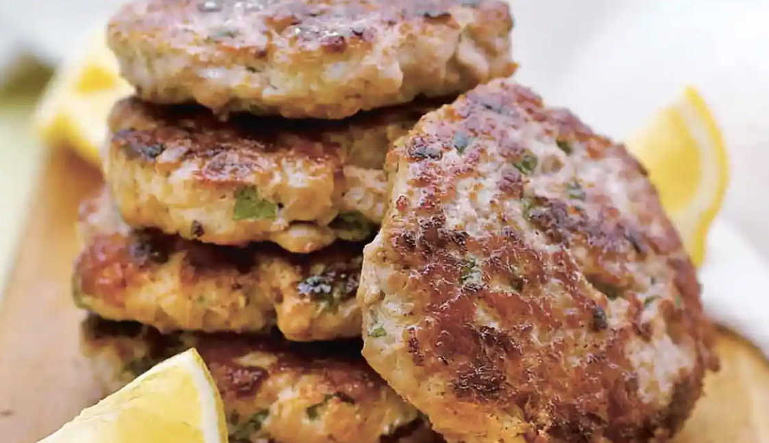 Light and lemony turkey burger patties on a plate, 22g protein per two-burger portion Light and lemony turkey burger patties on a plate, 22g protein per two-burger portion