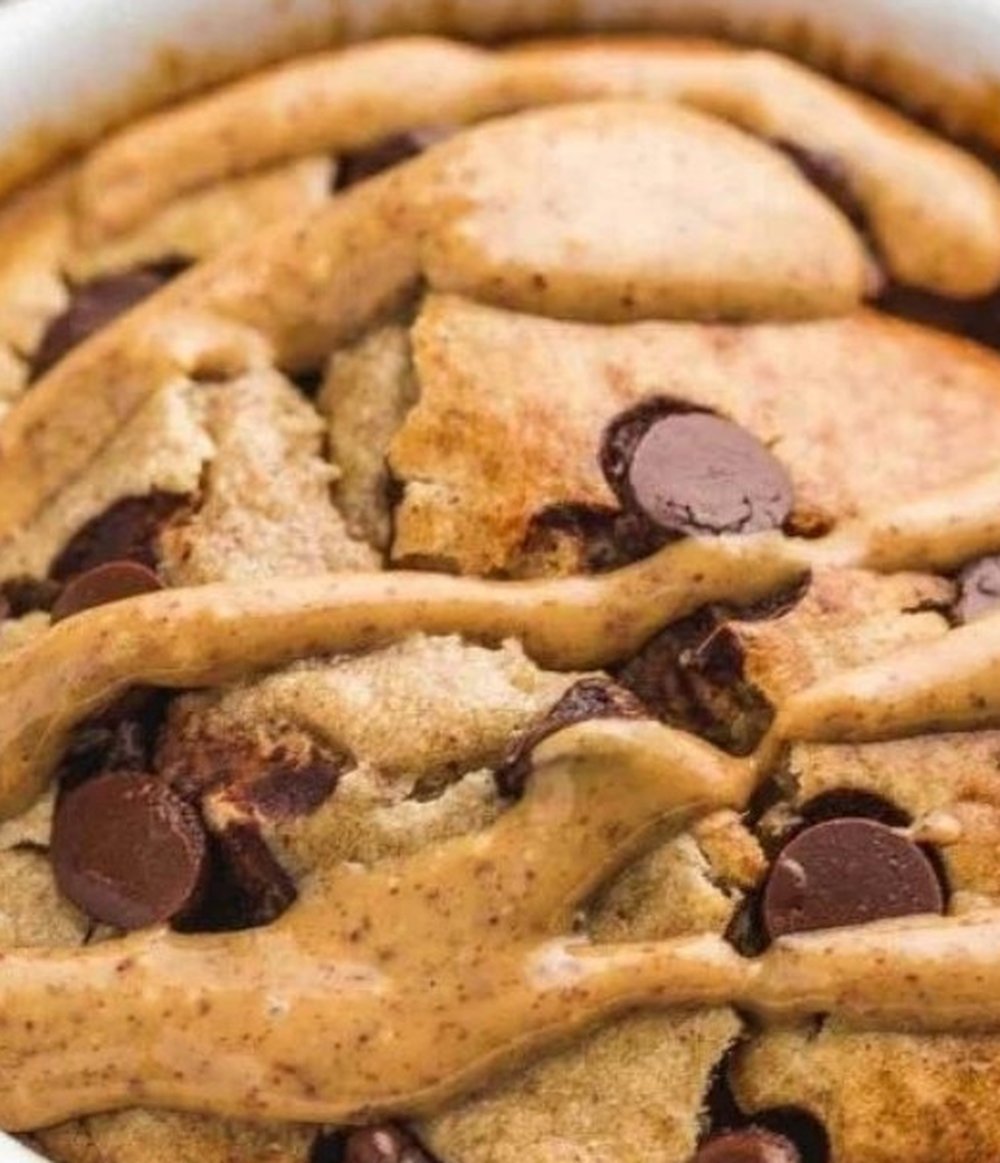Cinnamon roll protein baked oats in a white ramekin topped with nut butter and chocolate chips, 31g protein Cinnamon roll protein baked oats in a white ramekin topped with nut butter and chocolate chips, 31g protein