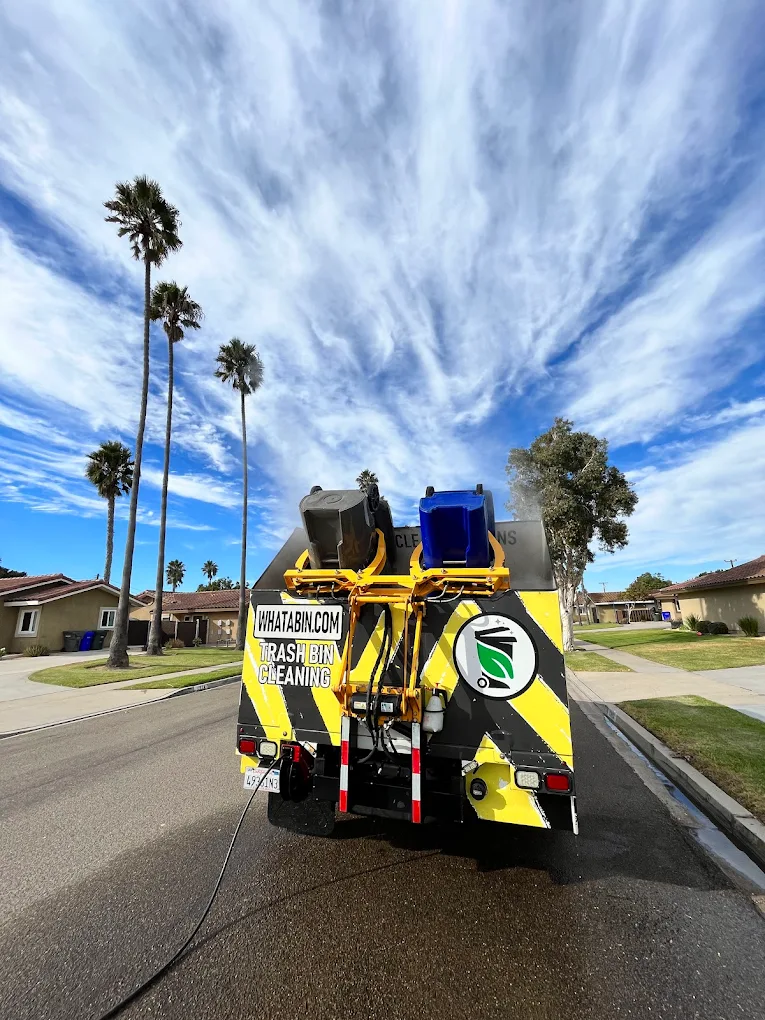What A Bin truck cleaning trash and recycle bins with a self-contained hot steam cleaning unit on a sunny residential street in San Diego, California.