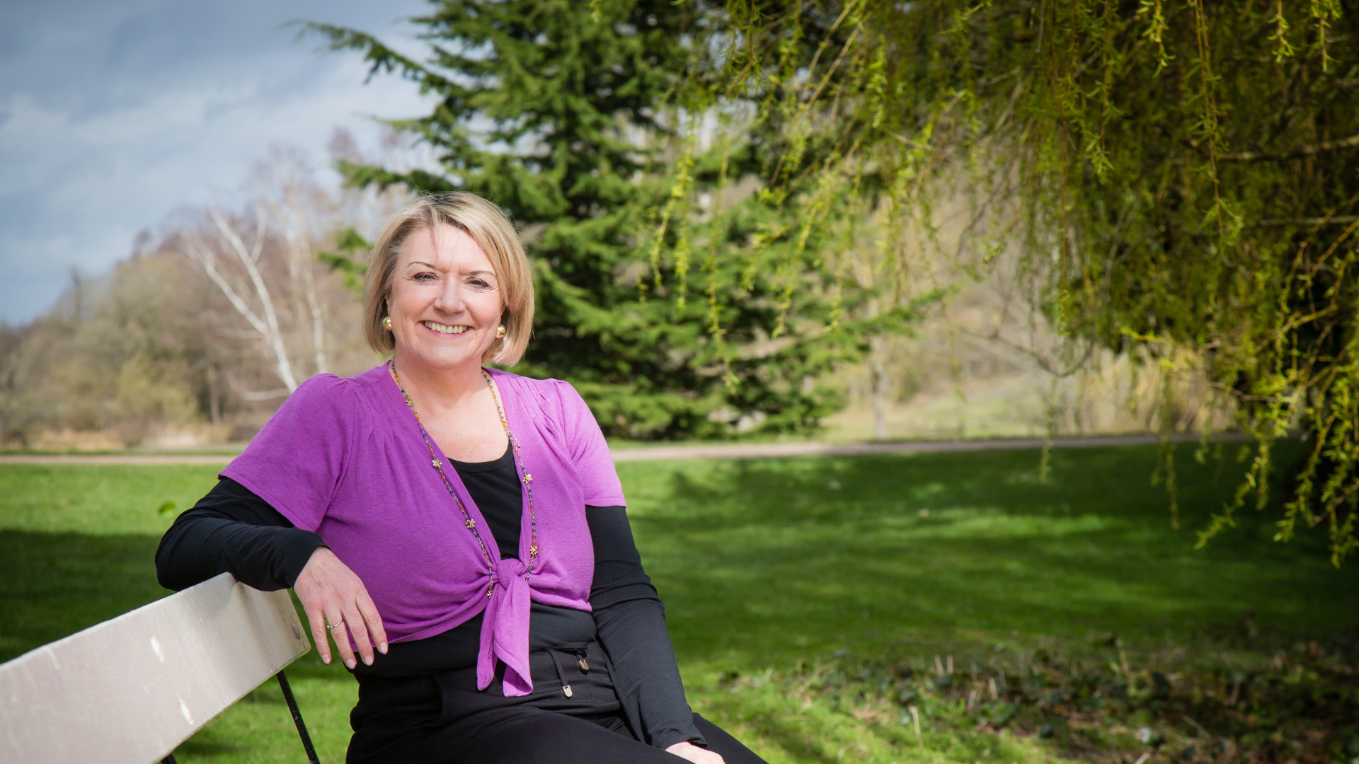 Steph Lee, founder of The Anchor Path, sitting on a bench in nature