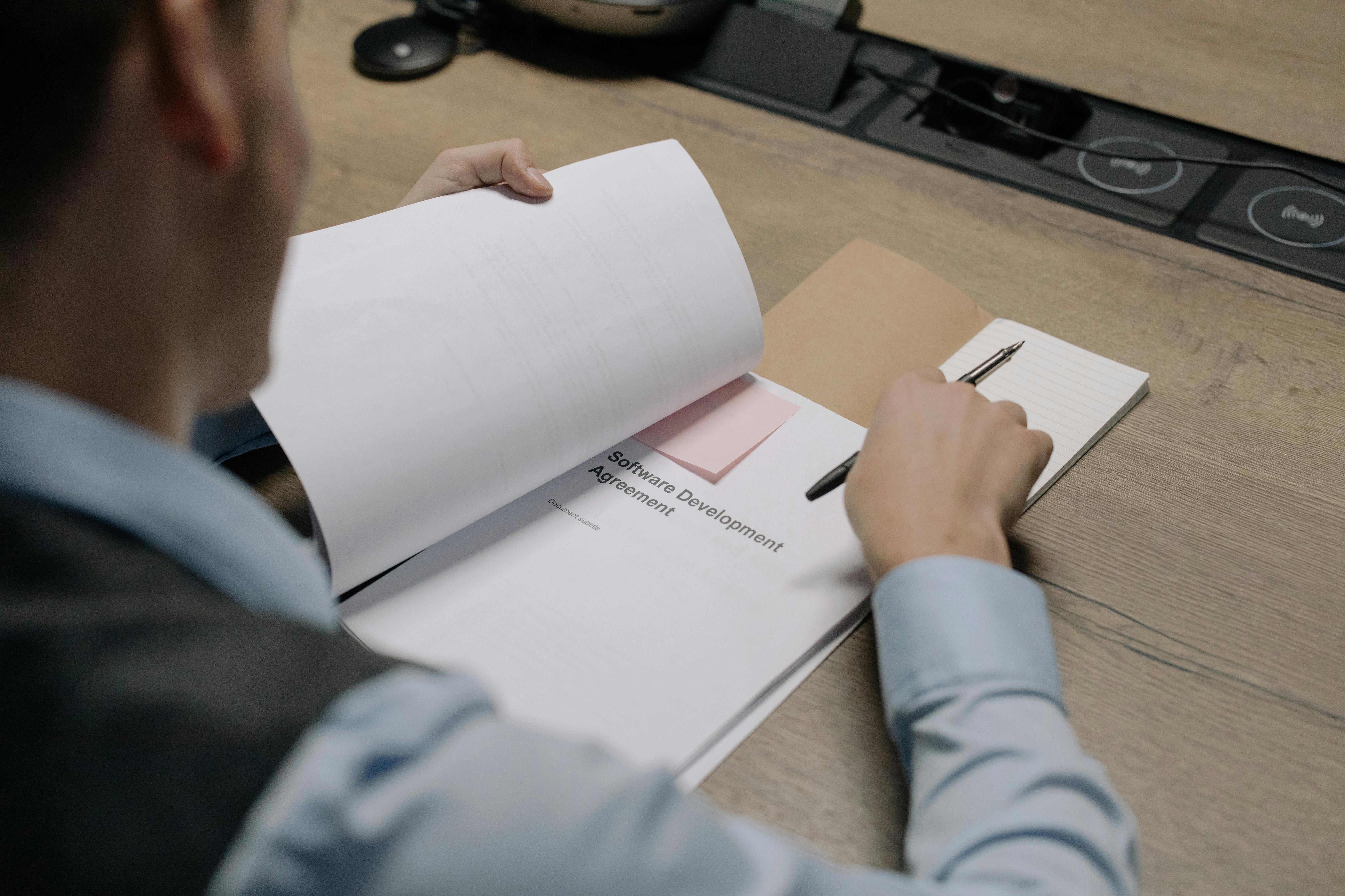 A person reading a document with a pen in hand