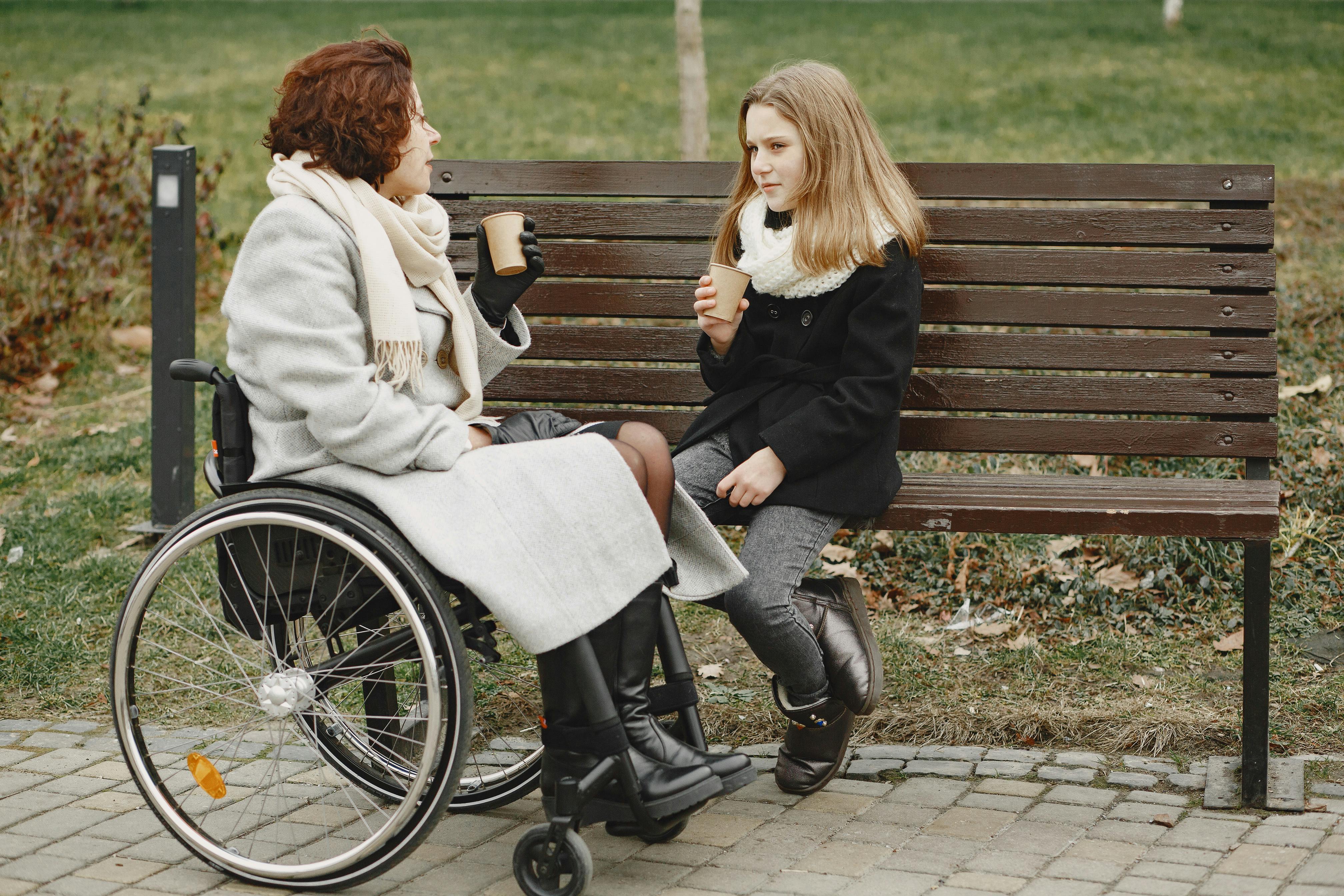  Two people sitting on a park bench talking
