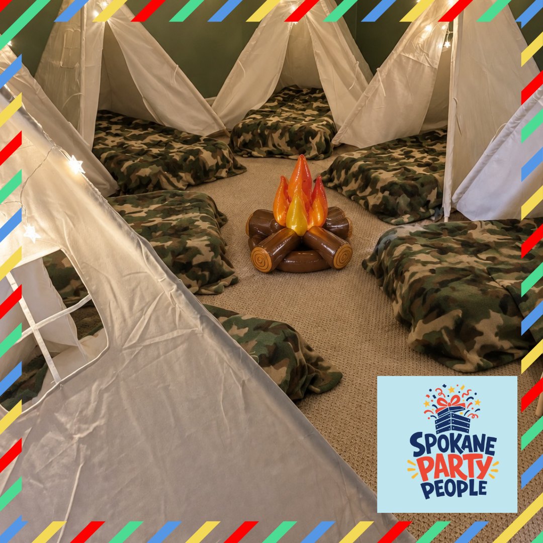 Campfire Campout Party setup with white teepees, string lights, camo blankets on air mattresses, and an inflatable campfire in the center