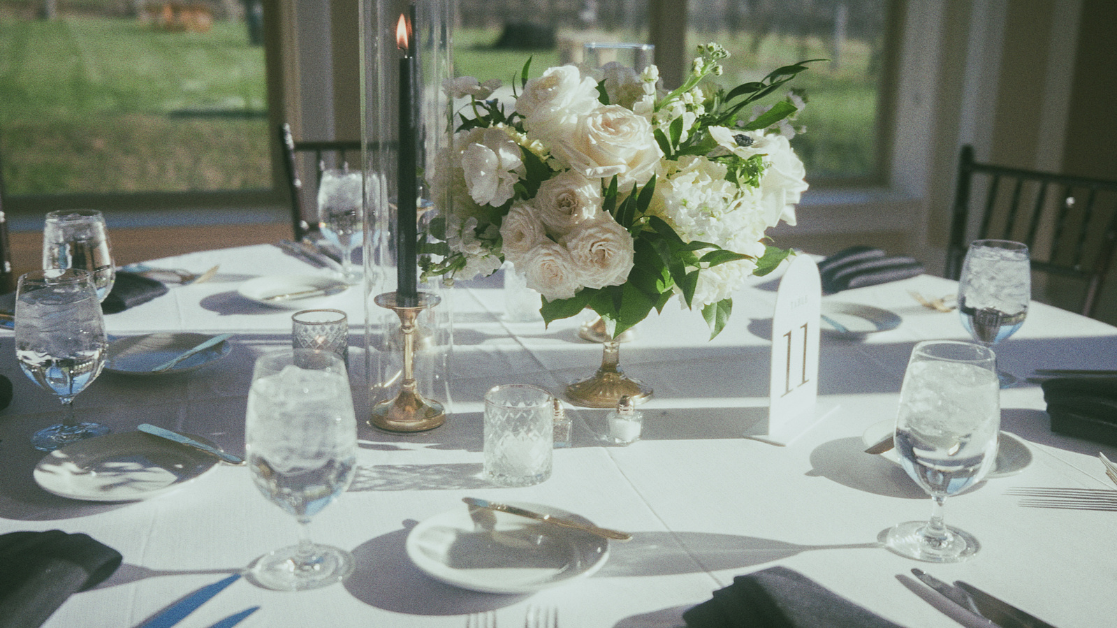 A wedding reception table set with florals and glassware
