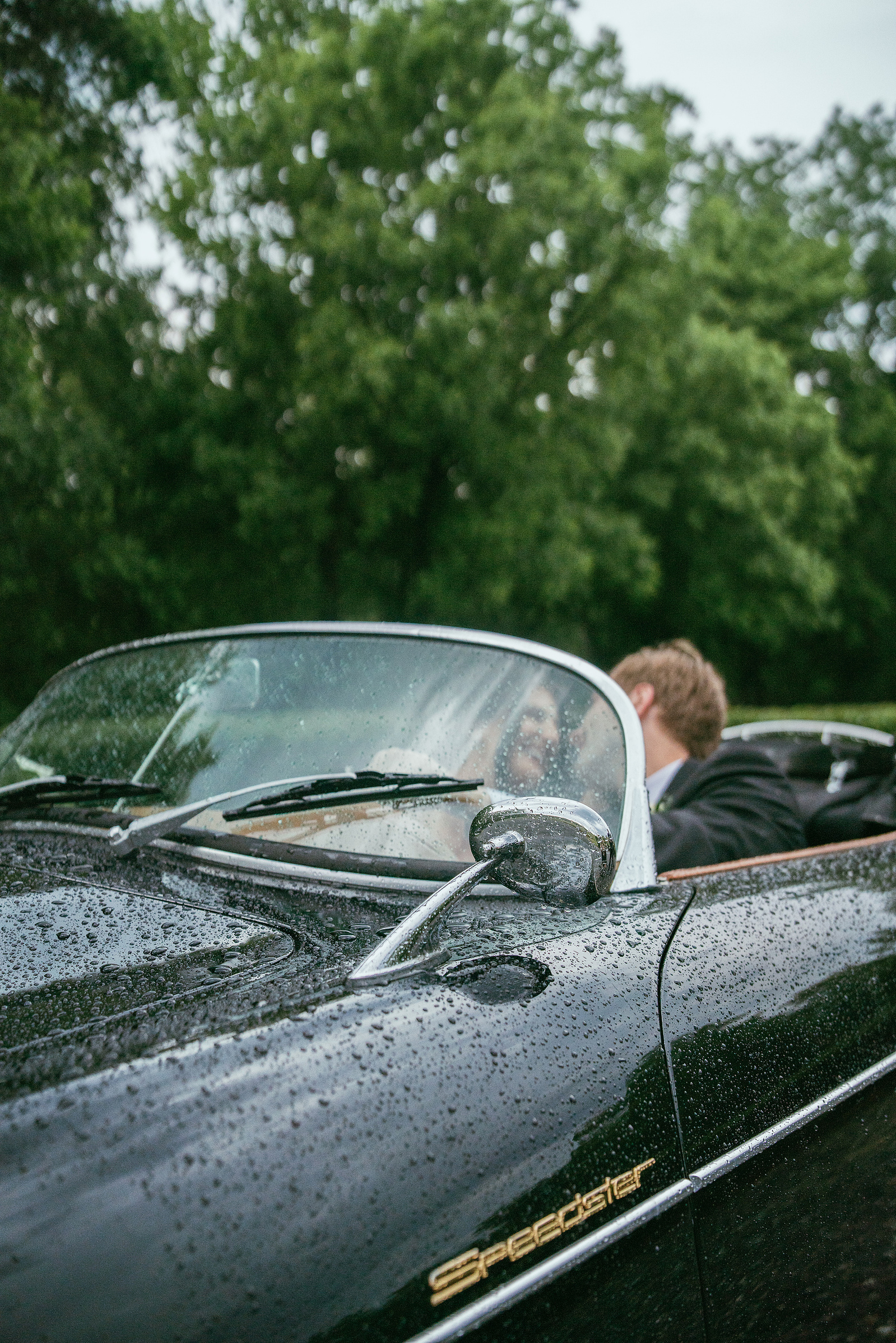 A couple in a vintage convertible on their wedding day