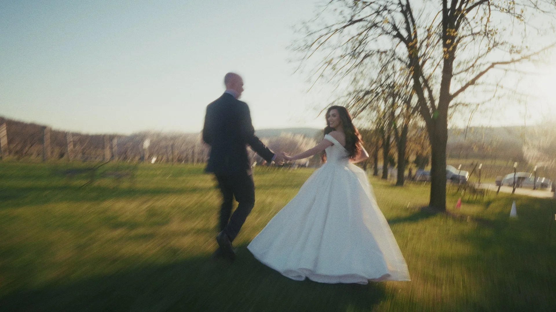 Shirin and Joe walking hand in hand across the lawn at Breaux Vineyards
