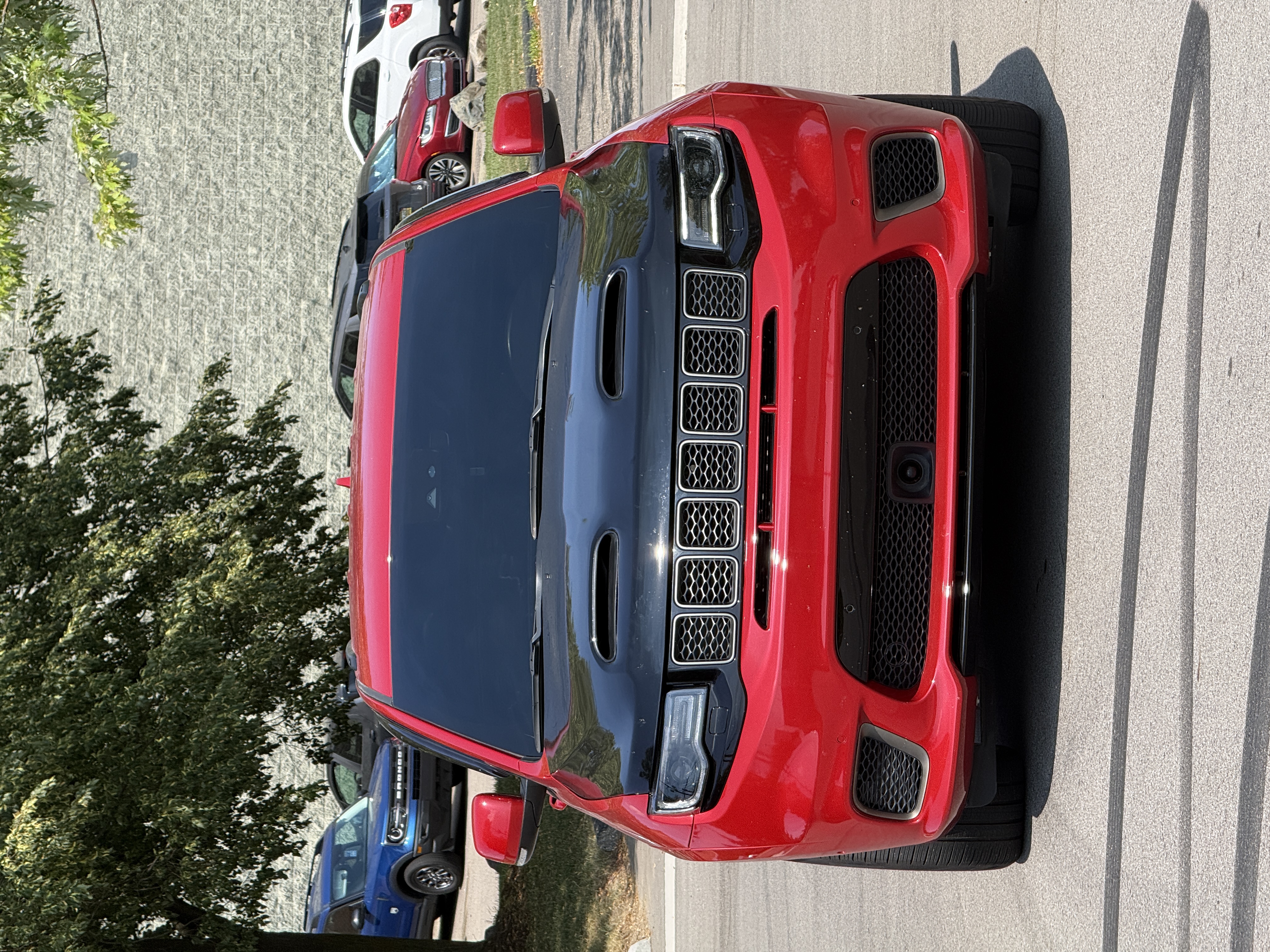Red Jeep Grand Cherokee with a black hood at Elevate Automotive