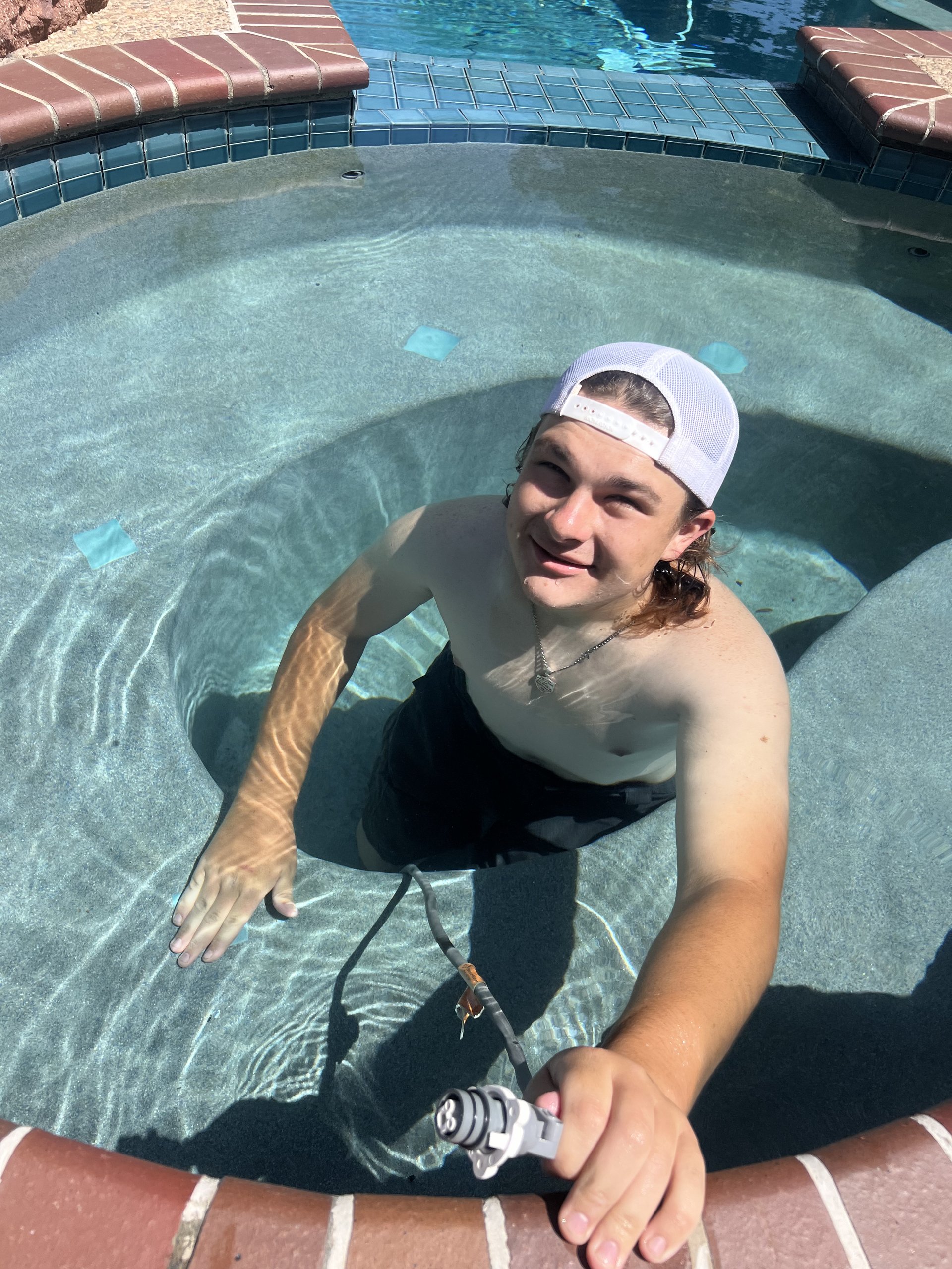 Pool service technician skimming a swimming pool