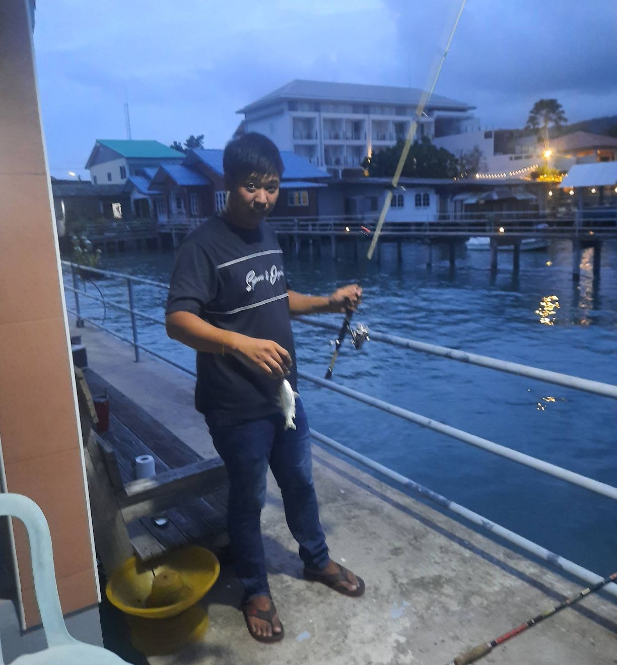 Night view of pier lights reflecting on the sea at Bang Sare