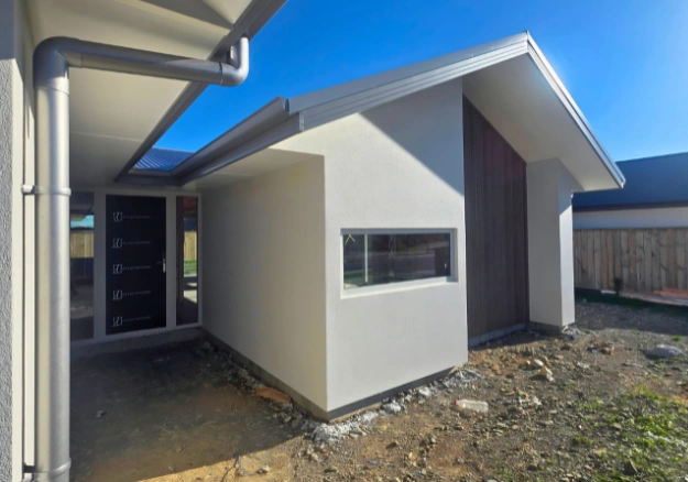 Exterior detail showing crisp lines and specialist plaster coatings applied on a modern Nelson home.