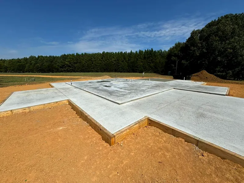 Large finished concrete foundation slab on a cleared lot