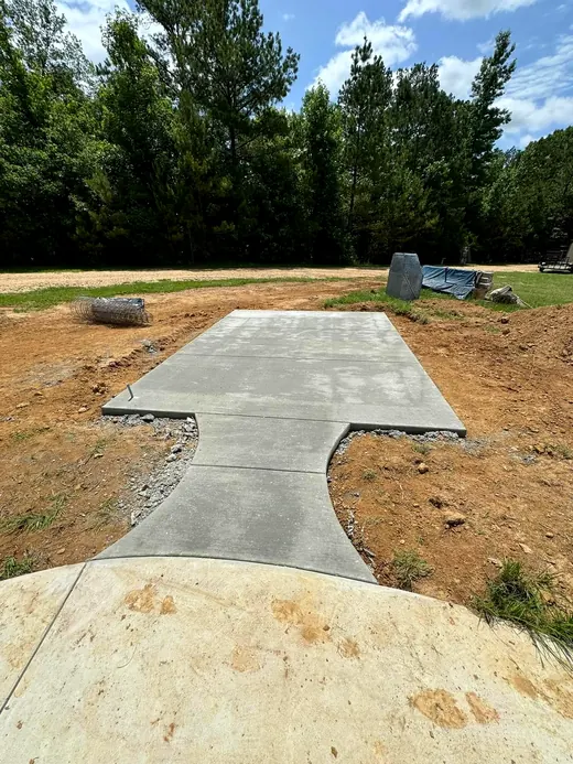 Concrete walkway leading to a poured pad