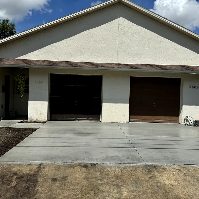 New concrete driveway poured in front of a two-car garage