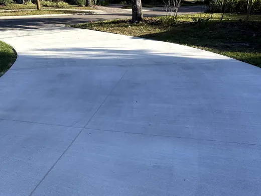 Wide new concrete driveway curving up from the street