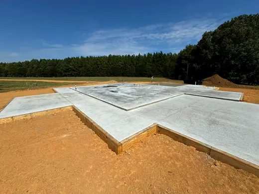 Large finished concrete foundation slab on a cleared lot