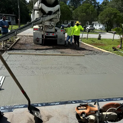 Crew pouring a new concrete driveway from a mixer truck