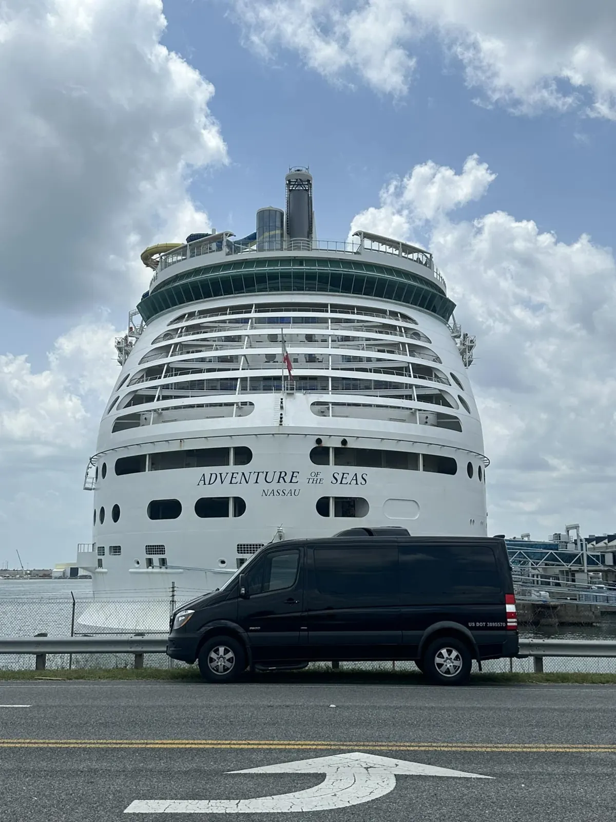 Black passenger van in front of the Adventure of the Seas cruise ship
