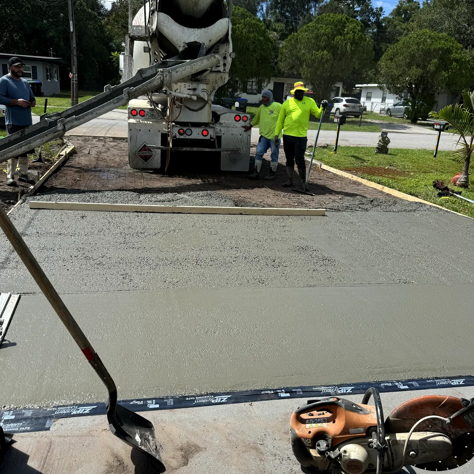 Crew pouring a new concrete driveway from a mixer truck