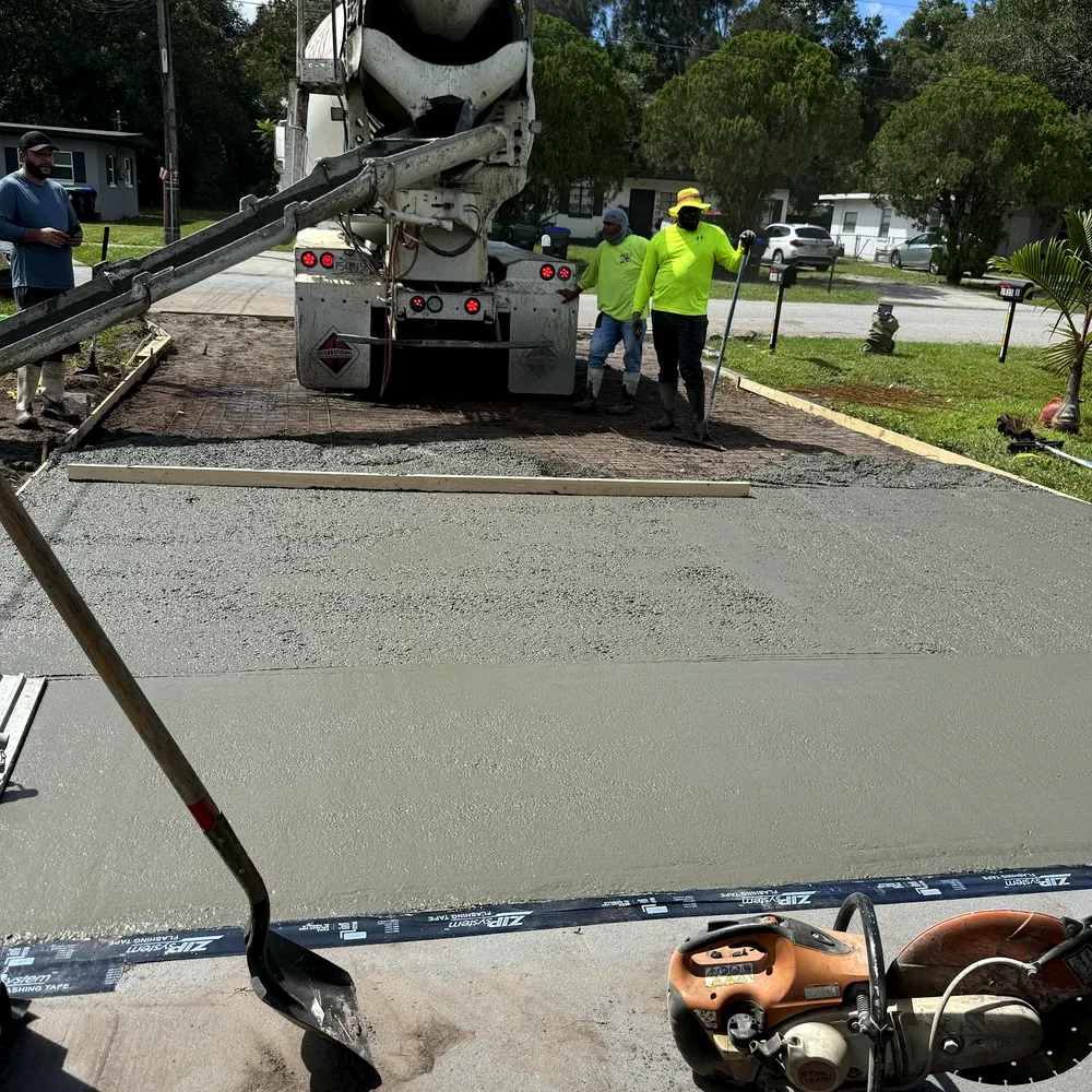 Crew pouring a new concrete driveway from a mixer truck