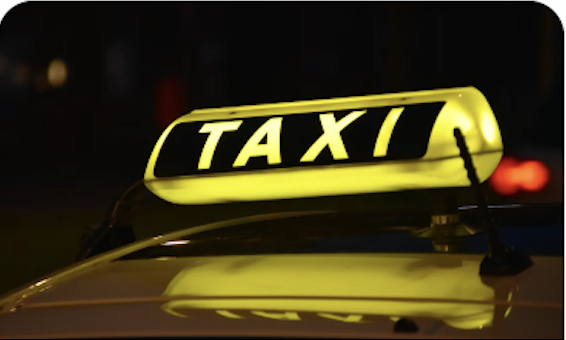 Taxi sign lit up at night