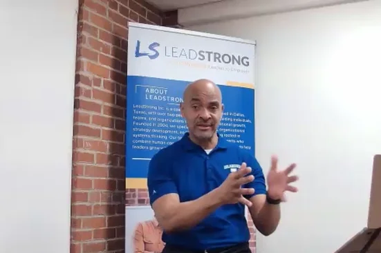 Reggie Carney coaching in front of a Lead Strong banner