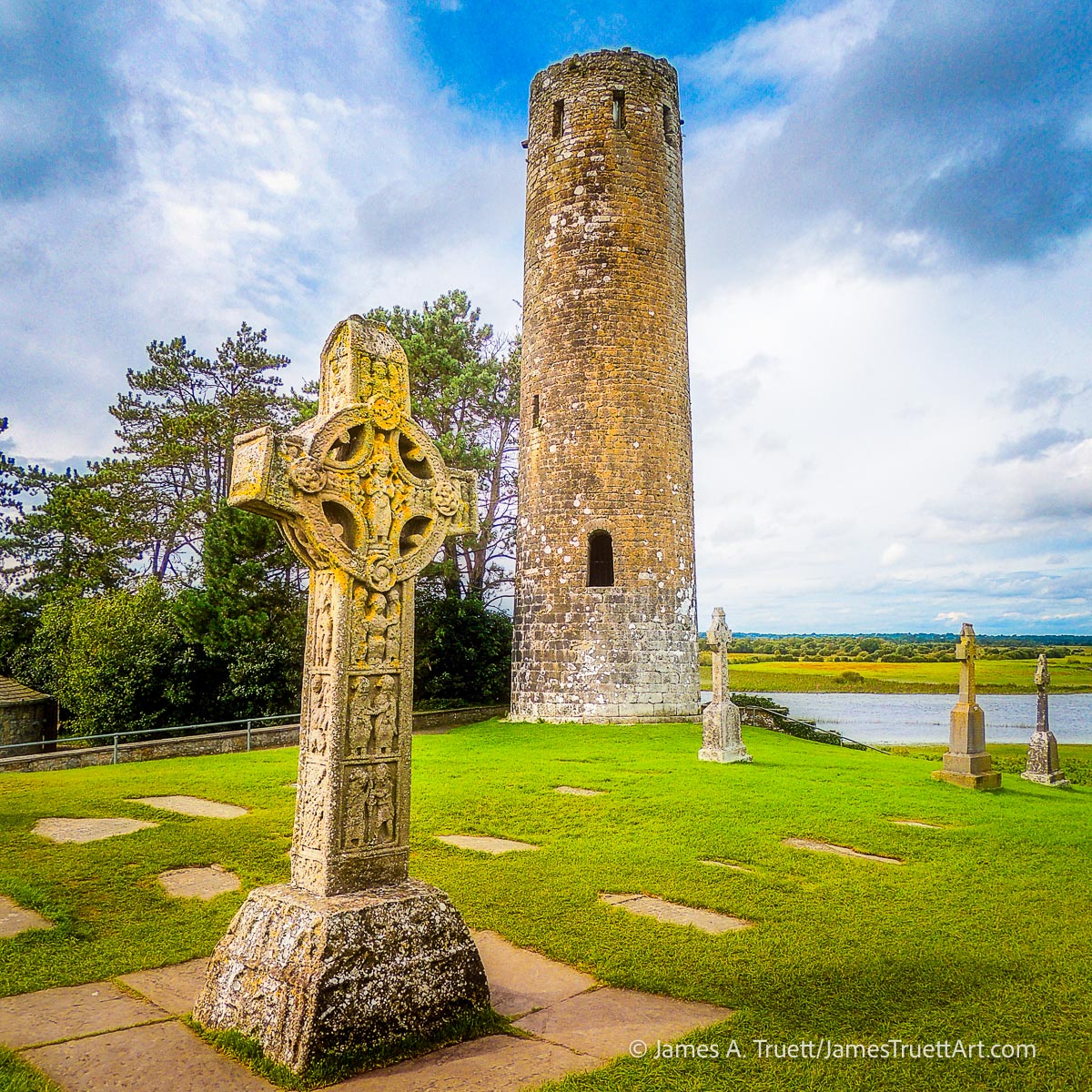 A Celtic Cross and tower ruins at Clonmacnoise.