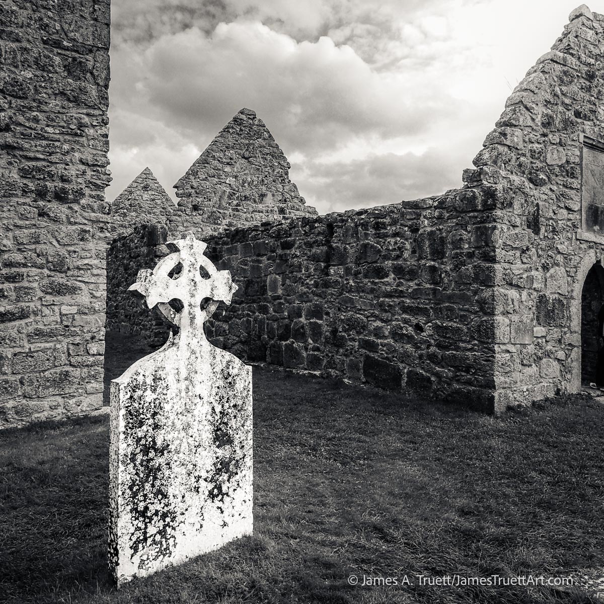 A whitewashed cross next to ruins at Clonmacnoise.