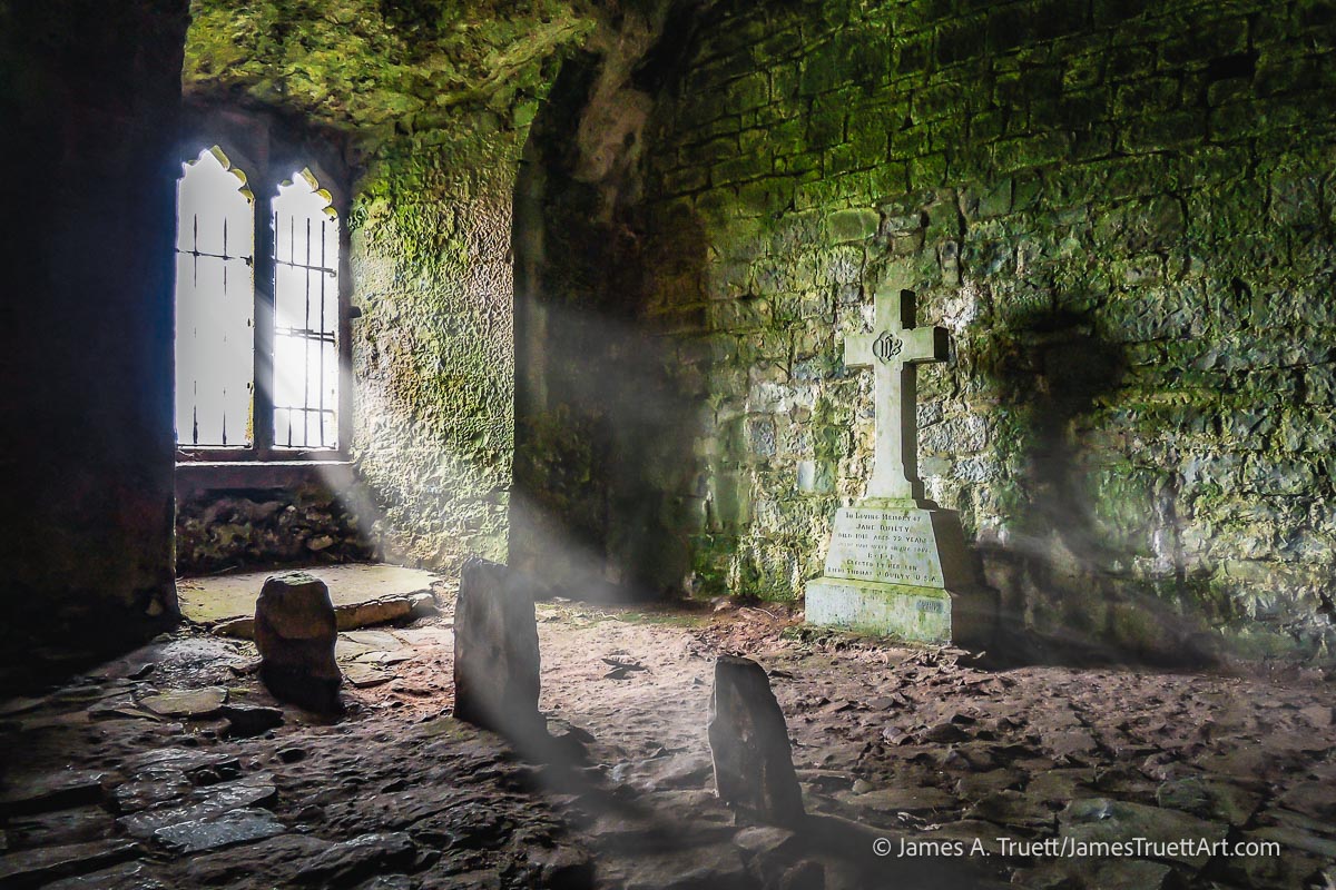 Sun streams through windows in one of the dark corners of Quin Abbey.