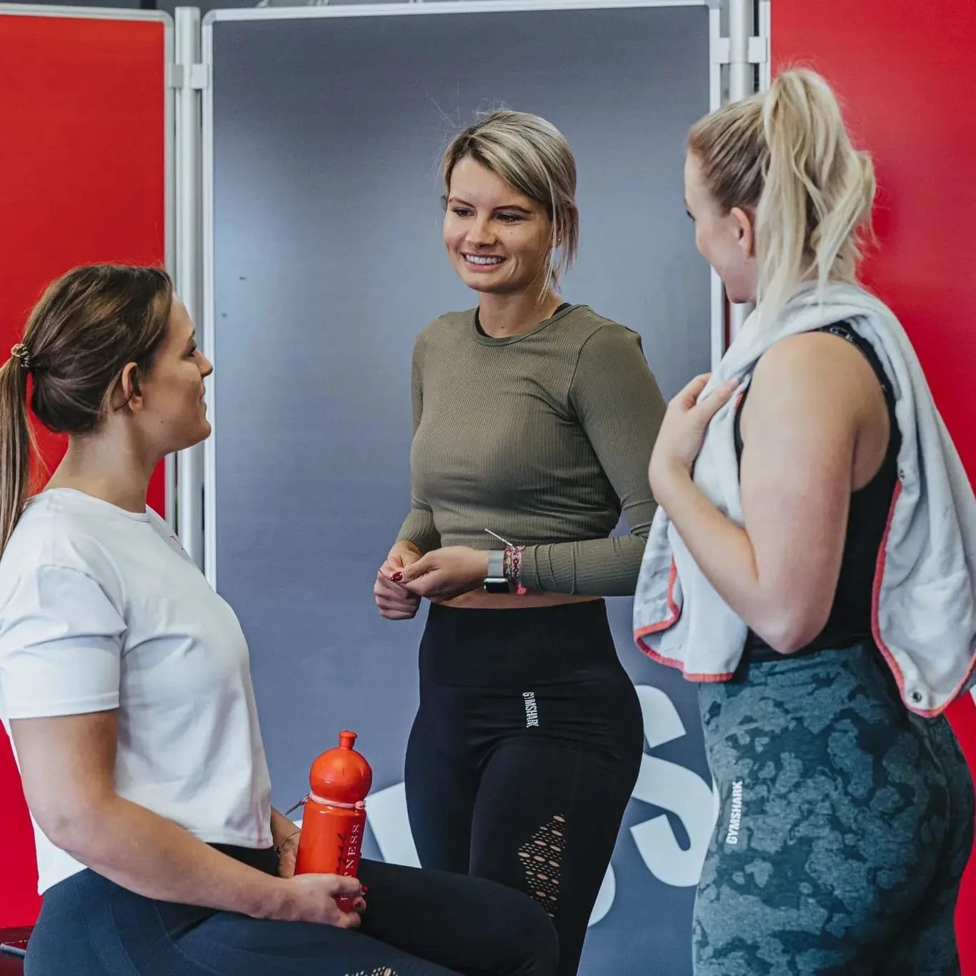 Drei Mitglieder unterhalten sich entspannt nach dem Training
