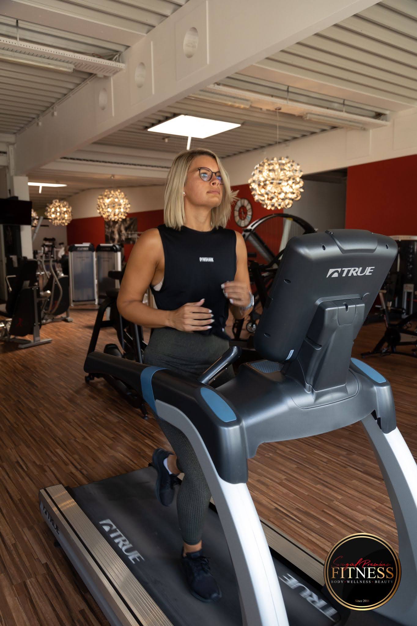 Mitglied joggt auf dem Laufband im modernen Trainingsbereich