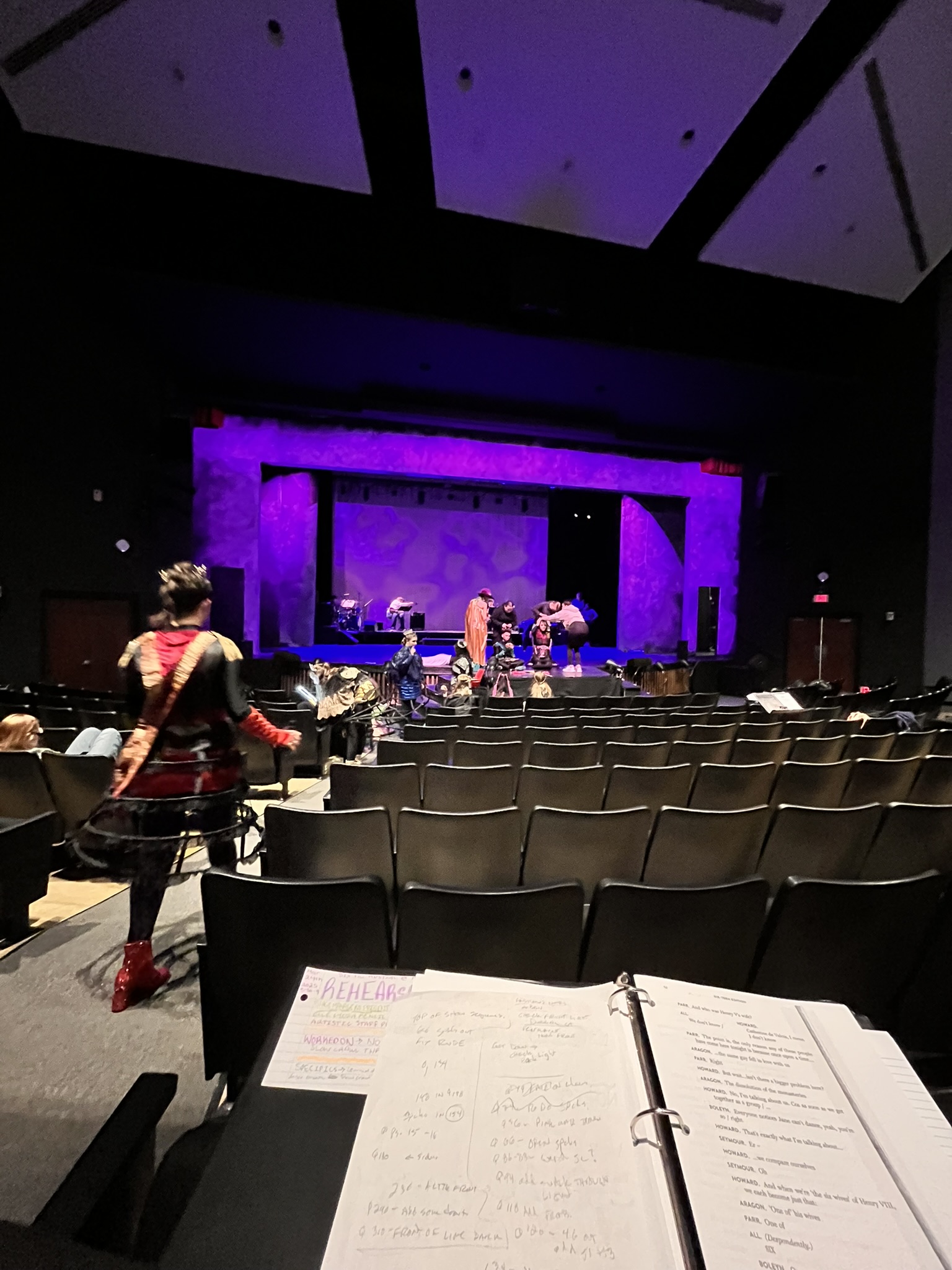 A stage during the rehearsal process, the arch lit vividly in purple. A stage during the rehearsal process, the arch lit vividly in purple.