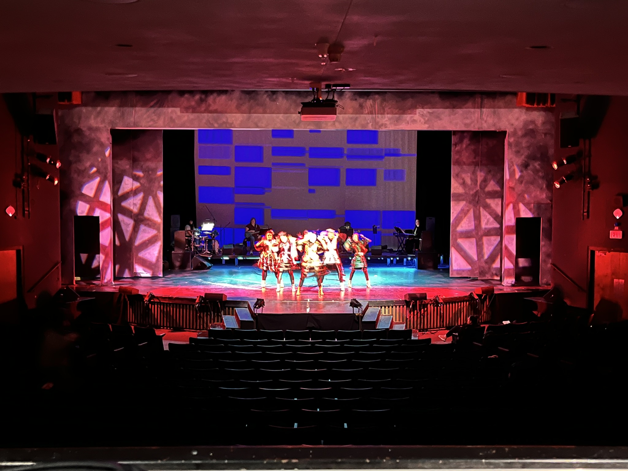 A full stage with patterned gobo lighting effects on the proscenium. A full stage with patterned gobo lighting effects on the proscenium.