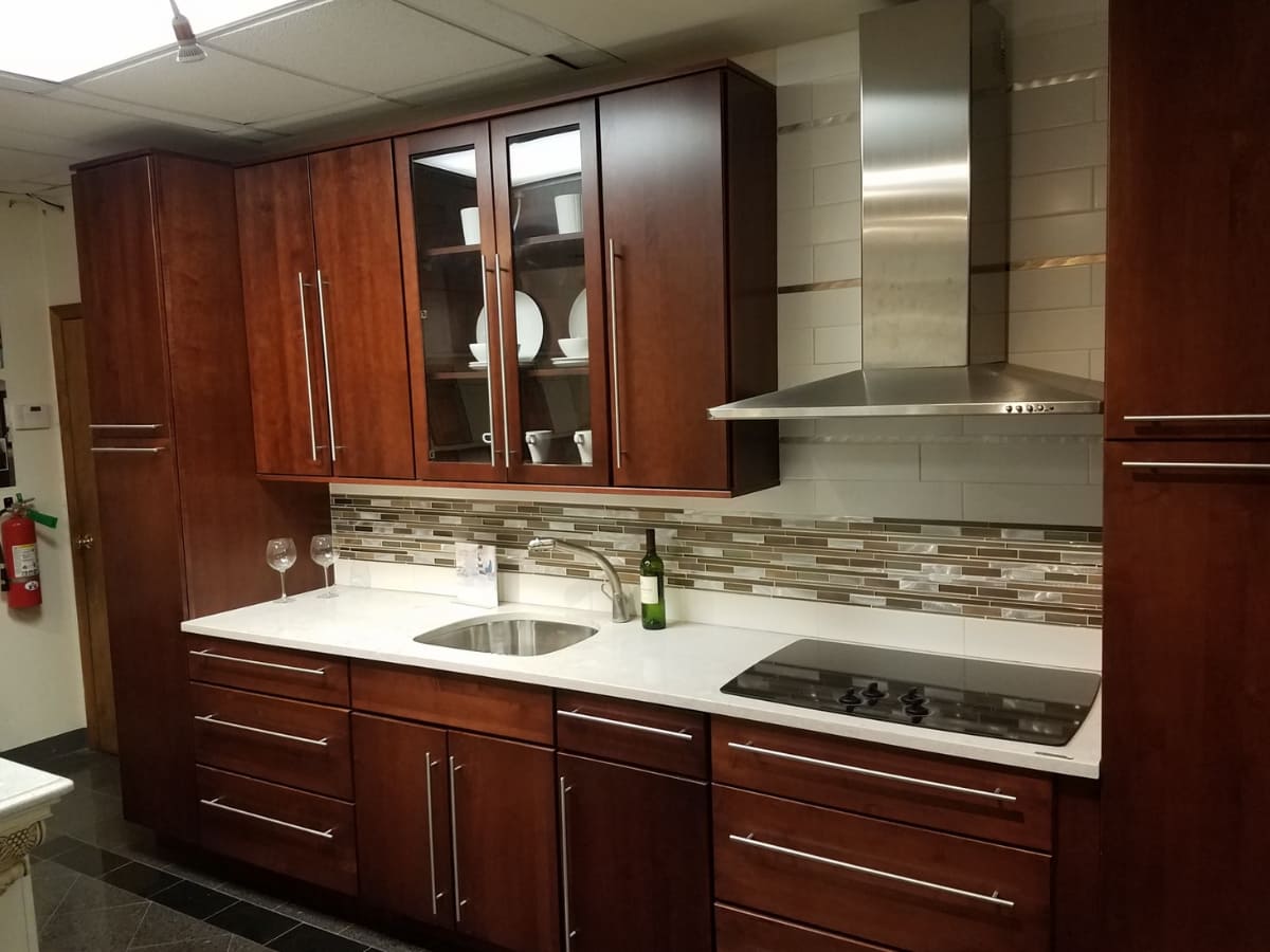 Sleek kitchen with waterproofed dark wood cabinets, stainless steel appliances, and a modern backsplash.