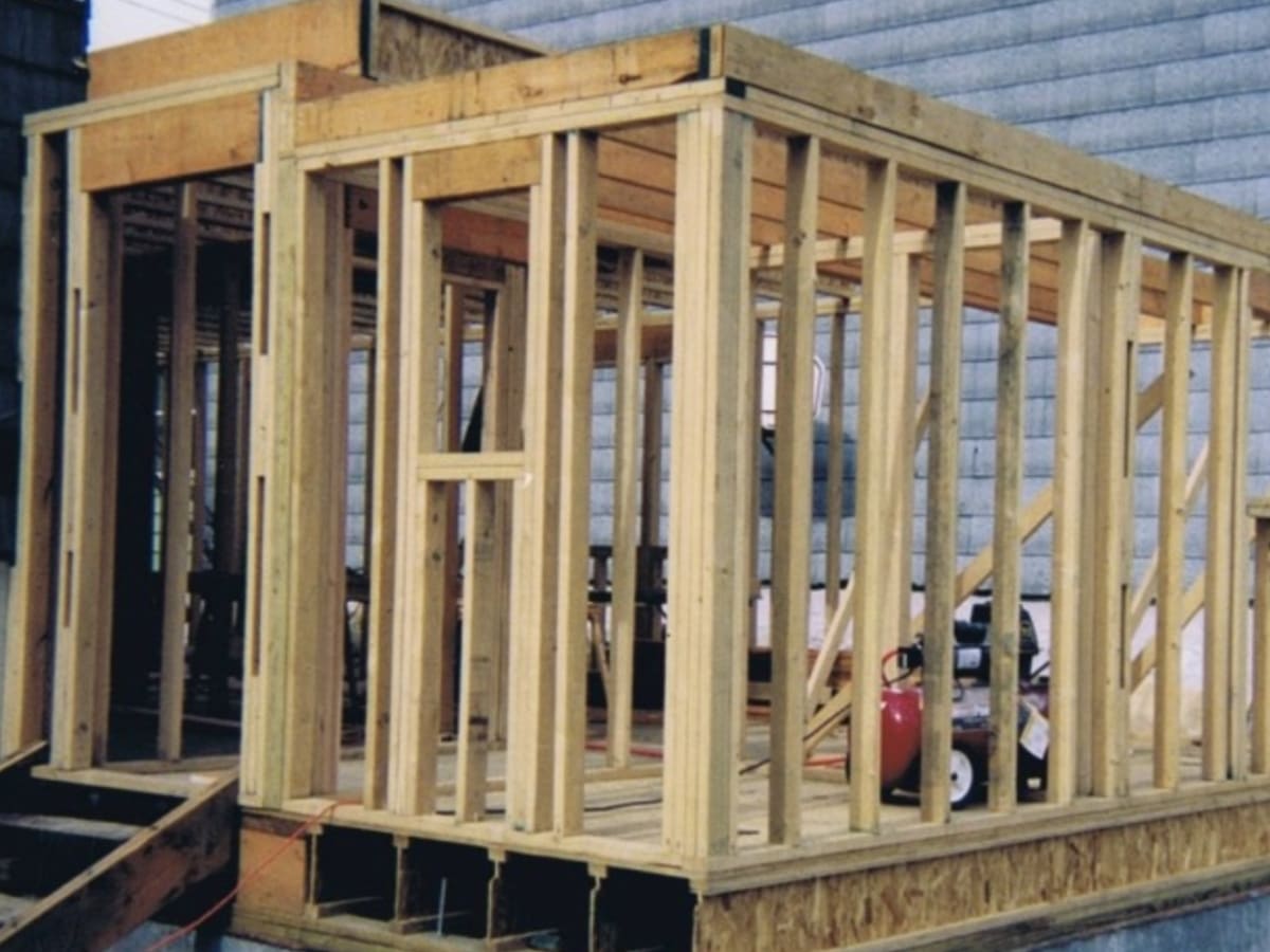 Newly framed addition to a house under construction, showcasing structural wood framing.